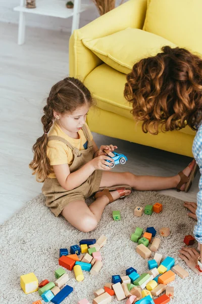 Visão Alto Ângulo Criança Bonito Segurando Carro Brinquedo Enquanto Sentado — Fotografia de Stock