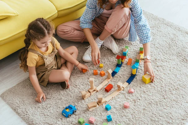 Corte Vista Babá Perto Adorável Criança Brincando Com Blocos Multicoloridos — Fotografia de Stock