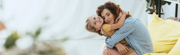 Imagen Horizontal Niñera Feliz Abrazando Niño Sonriente Mientras Está Sentado — Foto de Stock