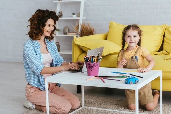 Happy Child Looking Camera While Drawing Nanny Working Laptop — Stock Photo, Image