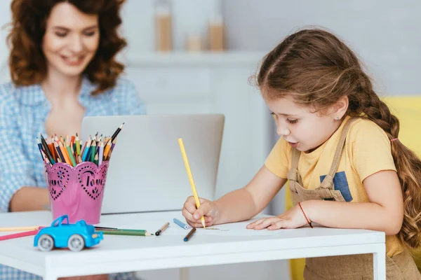 ラップトップで働くナニーに近いかわいい子供の絵の選択的な焦点 — ストック写真