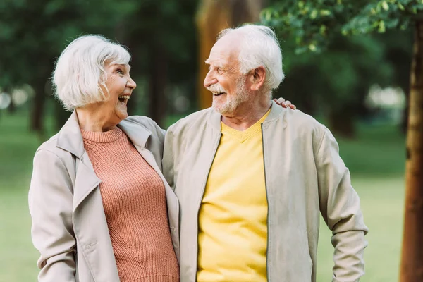 Cheerful Senior Couple Smiling Each Other While Embracing Park — Stock Photo, Image