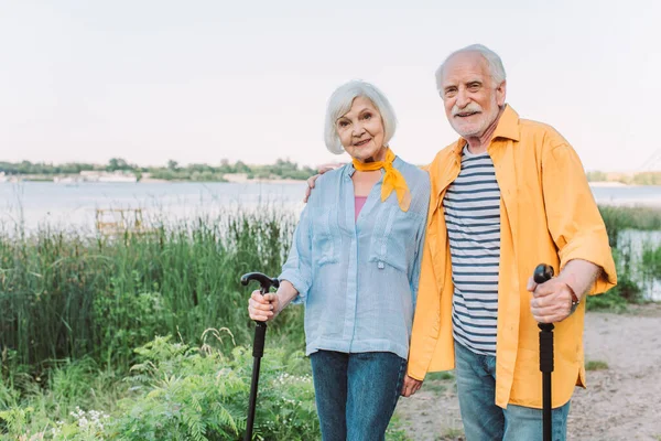 Smiling Senior Man Embracing Wife Walking Stick Park — Stock Photo, Image