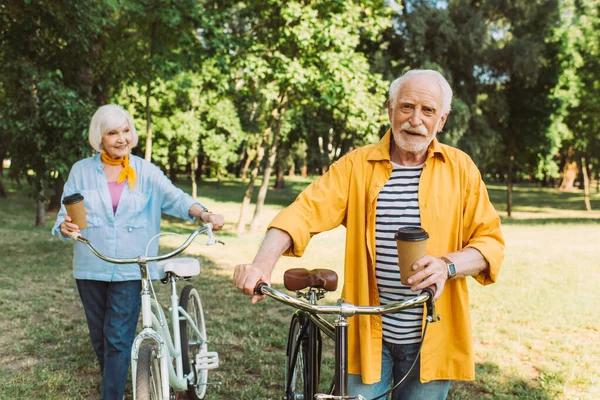 Selective Focus Smiling Senior Man Holding Paper Cup Wife Bike — Stock Photo, Image