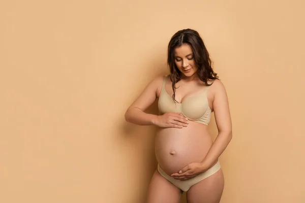 Jeune Femme Enceinte Sous Vêtements Touchant Ventre Sur Beige — Photo