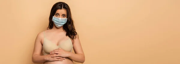Imagen Horizontal Morena Mujer Embarazada Máscara Protectora Tocando Barriga Beige — Foto de Stock