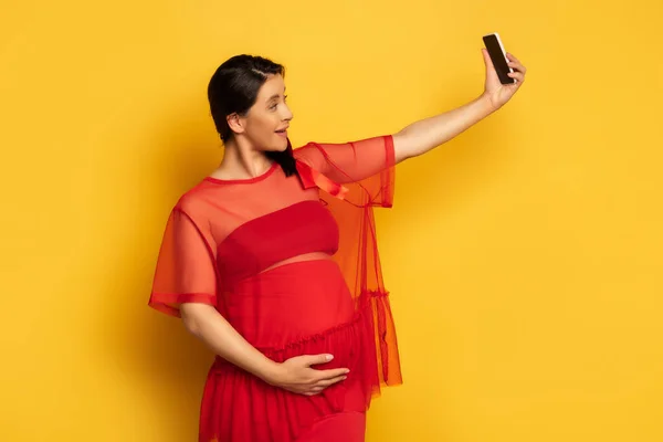 Pregnant Woman Red Tunic Touching Tummy While Taking Selfie Smartphone — Stock Photo, Image