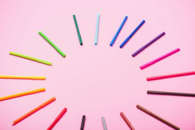 Pembe üzerine çok renkli keçeli kalemlerin boş çerçevesinin yüksek açılı görünümü