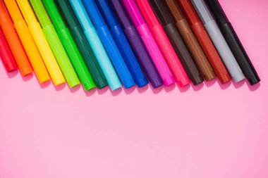 Fotokopi alanı olan pembe arkaplandaki renk keçeli kalemlerin üst görünümü