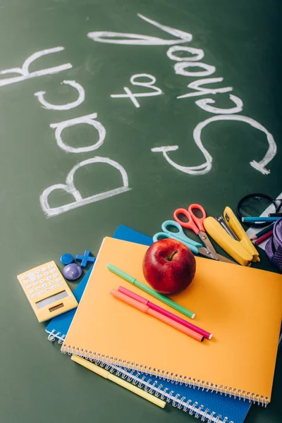 学校用品や緑の黒板の教科書に近い新鮮なリンゴの選択的焦点 — ストック写真