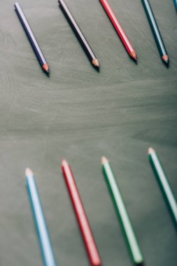 yeşil karatahta üzerinde çok renkli kalemlerin seçici odak noktası, yüksek açı görünümü