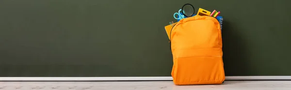 Horizontaal Beeld Van Gele Rugzak Vol Schoolbriefpapier Bureau Bij Groen — Stockfoto