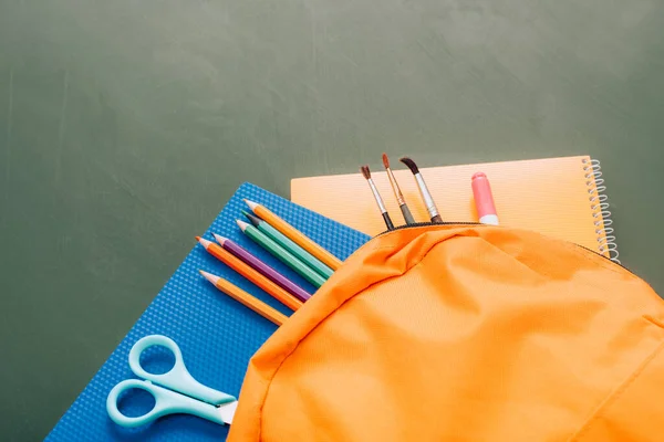 Hochwinkelaufnahme Eines Gelben Rucksacks Mit Schulmaterial Auf Grüner Tafel — Stockfoto