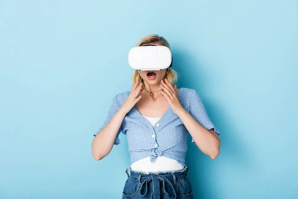 穿着蓝色的虚拟现实耳机的年轻而震惊的女人 — 图库照片