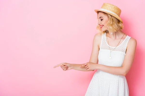 Vrouw Witte Jurk Strohoed Wijzend Met Vingers Wegkijkend Roze — Stockfoto