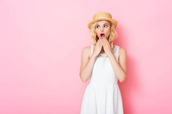 Chockad Ung Kvinna Halmhatt Täcker Munnen Och Tittar Bort Rosa — Stockfoto