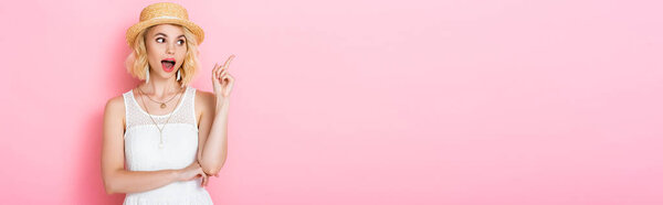 horizontal image of excited woman in straw hat having idea on pink 