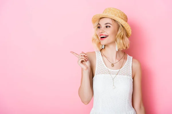 Jonge Vrouw Met Strohoed Wijzend Met Vinger Roze — Stockfoto