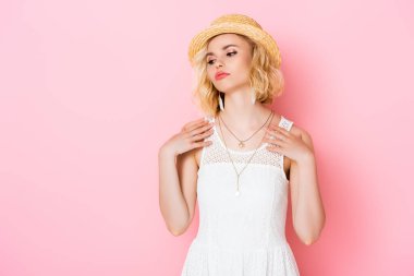 Hasır şapkalı yorgun genç bir kadın ve pembe elbiseli beyaz bir kadın. 