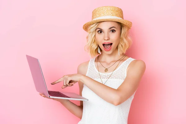 Mujer Excitada Sombrero Paja Apuntando Con Dedo Computadora Portátil Rosa — Foto de Stock