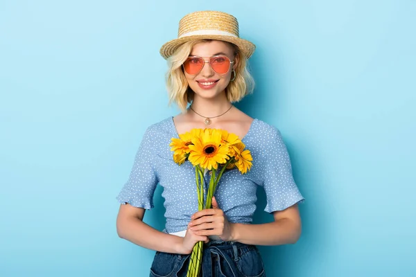 Femme Chapeau Paille Lunettes Soleil Tenant Des Fleurs Sur Bleu — Photo