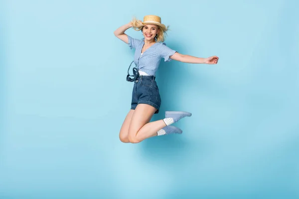 Молодая Женщина Шортах Соломенной Шляпе Прыгающая Голубом — стоковое фото