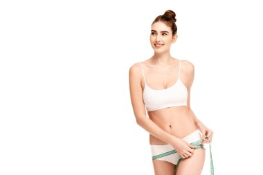 Mükemmel kalça ölçüleri olan genç bir model ve beyaz üzerinde izole edilmiş bir şekilde uzağa bakıyor. 