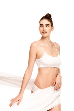 Üstte genç bir kadın şifon kumaşa dokunuyor ve beyaz elbiseye bakıyor. 