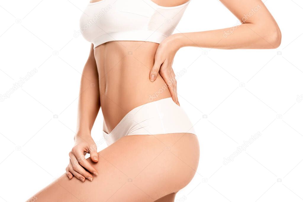 cropped view of young woman in top and panties standing with hand on hip isolated on white 