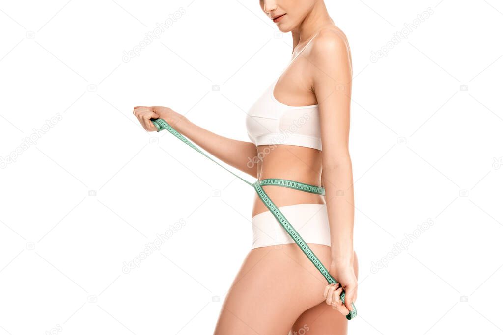 partial view of woman measuring waist with measuring tape isolated on white 