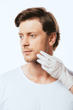 Dermatolog beyaz tenli hastaların yüzüne dokunuyor.
