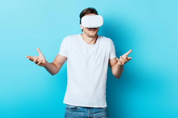 Hombre Camiseta Blanca Auriculares Mostrando Gesto Encogiéndose Hombros Sobre Fondo — Foto de Stock