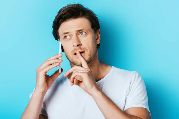 Gedachte Man Met Vinger Buurt Lippen Praten Smartphone Blauwe Achtergrond — Stockfoto