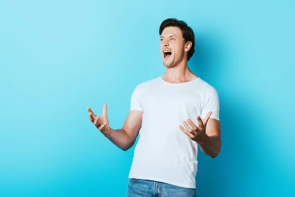 Hombre Enojado Camiseta Blanca Gritando Sobre Fondo Azul —  Fotos de Stock