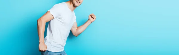 青い背景に白いTシャツの男のパノラマ作物 — ストック写真
