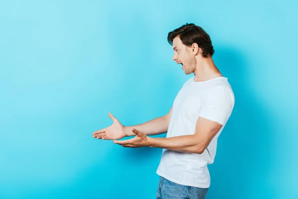 Hombre Impactado Señalando Con Las Manos Sobre Fondo Azul — Foto de Stock