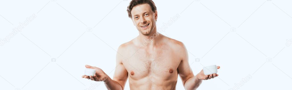 Panoramic orientation of shirtless man holding jars of cosmetic creams isolated on white