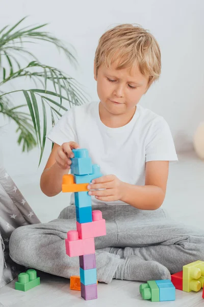 Concentrated Boy Pajamas Sitting Floor Playing Colorful Building Blocks — Stock Photo, Image