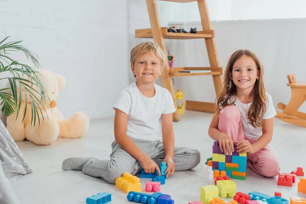 Excited Brother Sister Pajamas Sitting Floor Building Blocks Looking Camera — Stock Photo, Image