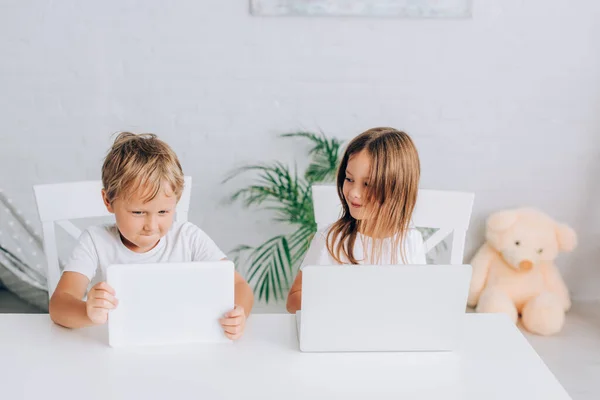 Kakak Dan Adik Duduk Meja Sementara Dan Menggunakan Laptop Bersama — Stok Foto