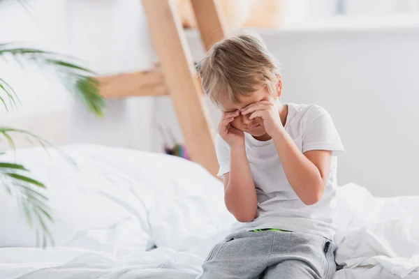 Väckt Pojke Vidröra Ögon Medan Sitter Sängen Pyjamas — Stockfoto