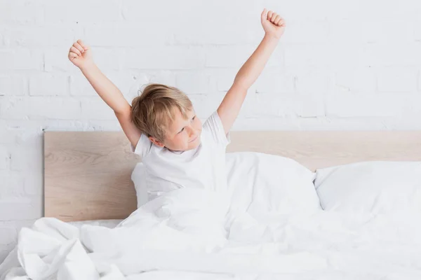 Awakened Boy White Shirt Stretching Looking Away While Sitting Bed — Stock Photo, Image