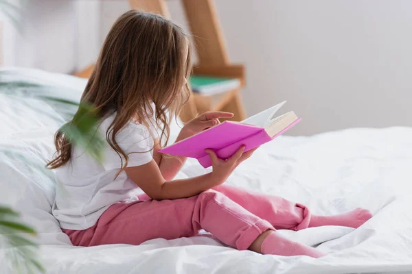Lány Pizsamában Ágyon Könyvet Olvas Reggel — Stock Fotó