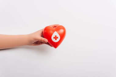 Kırpılmış kadın eli beyaz üzerinde kırmızı kalp, kan bağışı konsepti