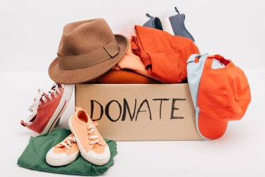 cardboard box with donated accessories, clothes and footwear isolated on white, charity concept clipart