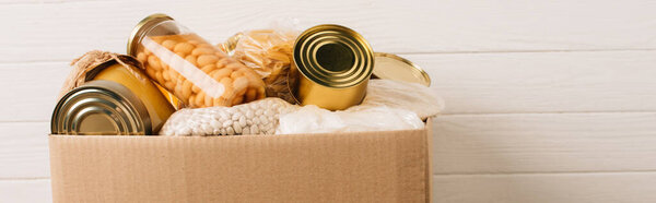 панорамный снимок картонной коробки с подарочной пищей на деревянном фоне, концепция благотворительности