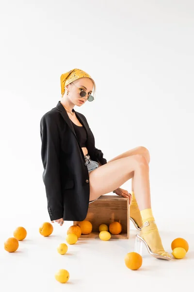 Módní Žena Pózuje Dřevěné Krabici Blízkosti Rozptýlené Citrusové Plody Bílém — Stock fotografie