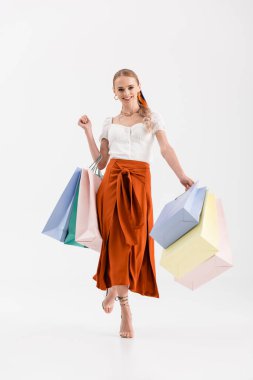 Beyaz poşetlerle gezen zarif bir kadın manzarası.