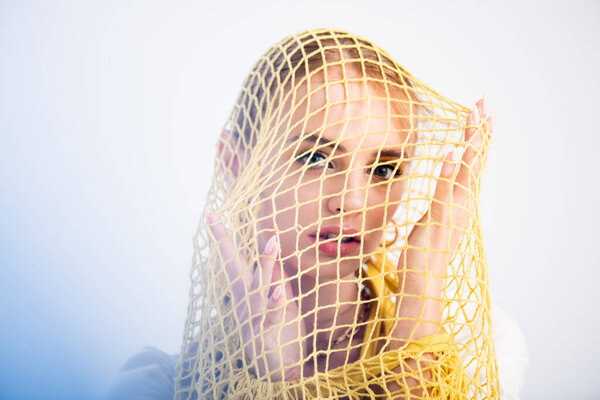 woman posing in yellow string bag on white background