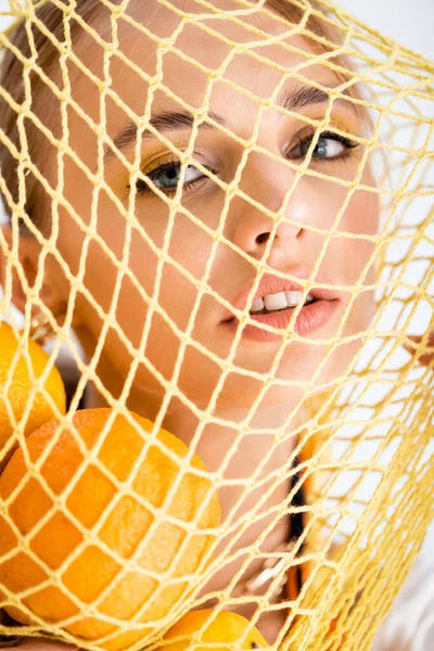 İp torbasında narenciye meyveli kadın portresi.